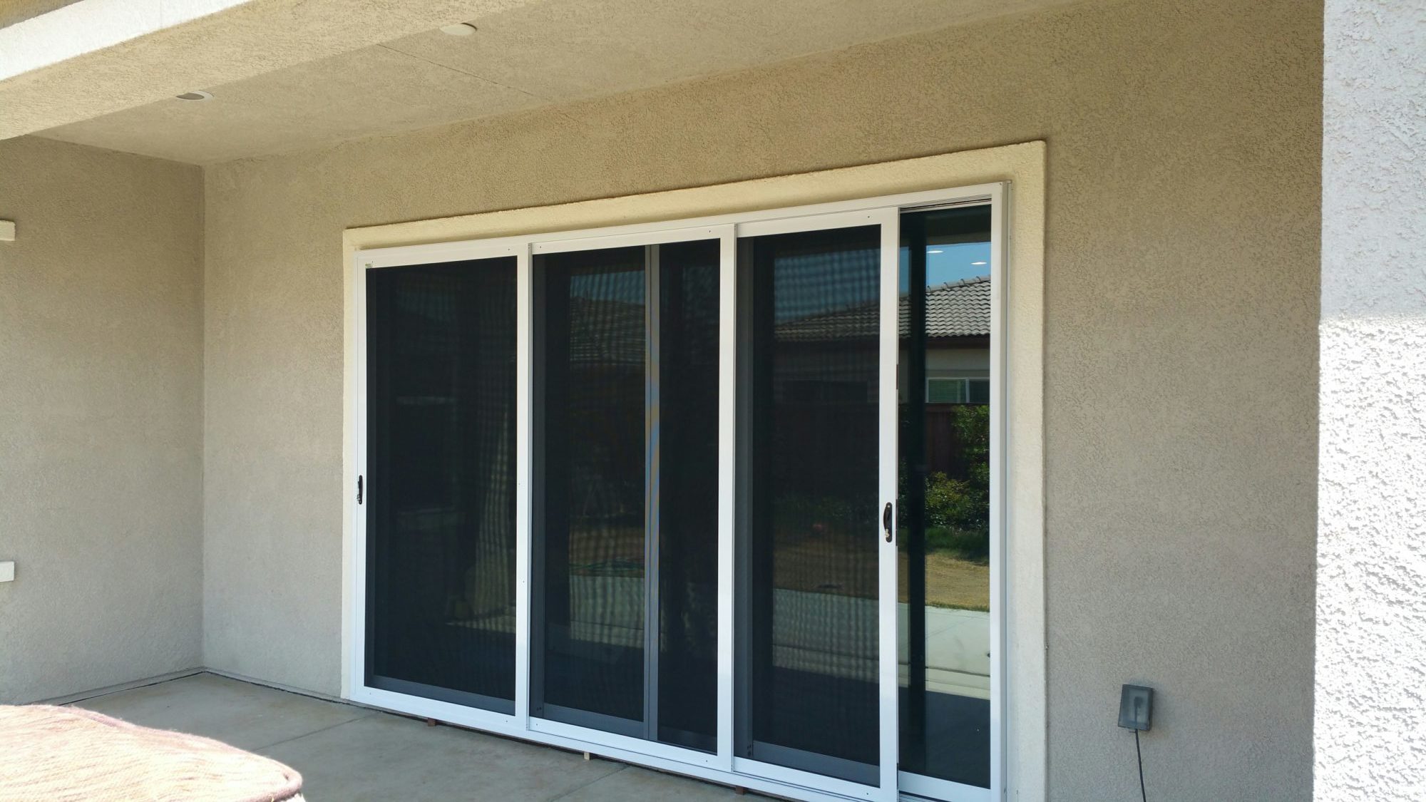 Triple bypass sliding security screen doors on a covered Delano patio