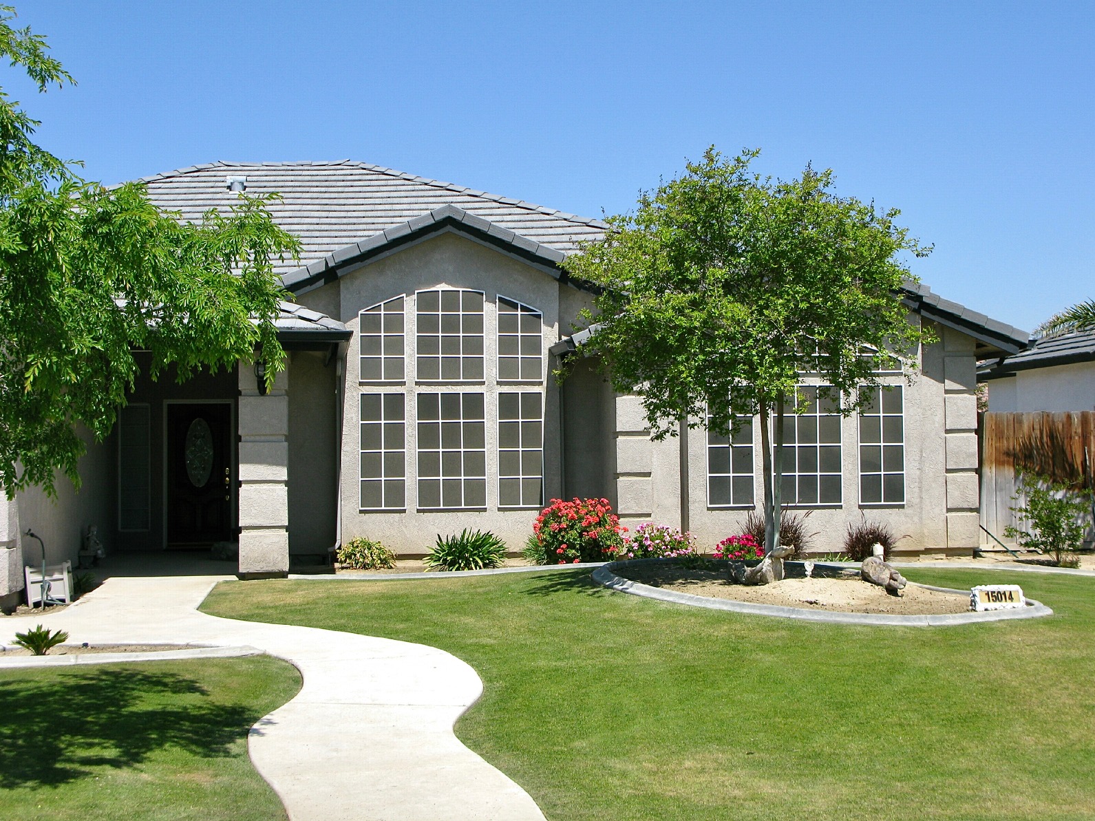 Front elevation of a Bakersfield home with sunscreens on tall arched windows